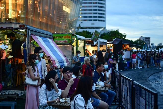 지난 7일(현지시간) 태국 방콕 짜오프라야 강 인근 쇼핑몰 바깥에서 사람들이 음악 분수를 기다리고 있다. AFP연합뉴스