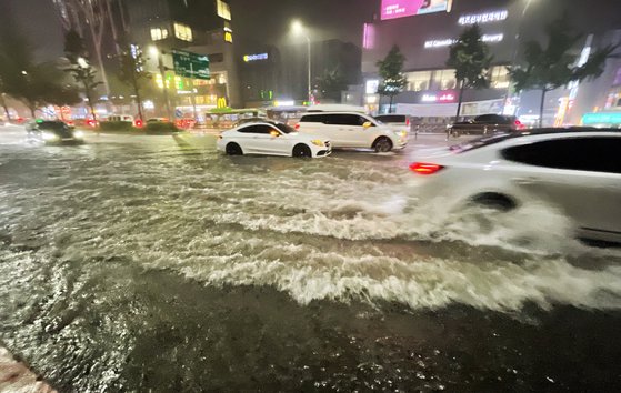 지난 8일 밤 서울 강남구 신사역 일대 도로가 폭우로 물에 잠겨 있다. 온실가스를 줄이지 않으면 21세기 말에는 여름철 호우 발생일 수가 지금보다 15일가량 늘어날 것이란 연구 결과가 나왔다. 연합뉴스