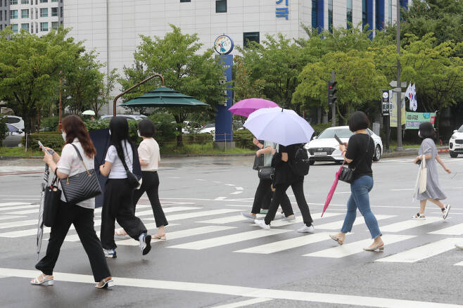 16일 오전 광주 서구 치평동에서 시민들이 가늘어진 빗줄기에 우산을 접고 출근하고 있다. [연합]