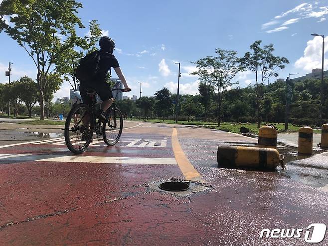 20일 오전 서울 서초구 세빛섬 자전거 도로에서 한 시민이 폭우로 만들어진 물웅덩이를 피해 자전거를 타고 있다. 2022.8.20/뉴스1