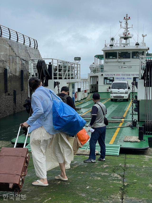 휴가를 마친 여행객들이 육지로 가는 배를 타기 위해 이동하고 있다. 바닥에 이끼가 끼어 상당히 미끄럽다.