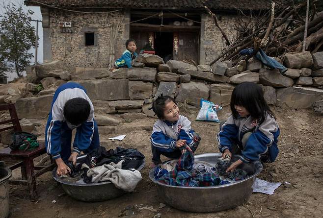 부모가 농민공으로 일하기 위해 도시로 떠나고 시골에 남겨진 아이들이 빨래를 하고 있다. (사진: 2016.12.18 게티이미지)