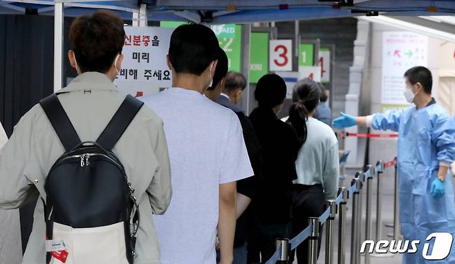 22일 오전 서울 용산구보건소 신종 코로나바이러스 감염증(코로나19) 선별진료소를 찾은 시민들이 검사를 받기 위해 줄을 서고 있다. /뉴스1 ⓒ News1