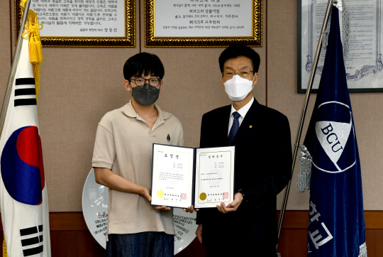 백석문화대 박세중 학생(왼쪽)이 송기신 총장에게 표창장을 받고 기념촬영을 하고 있다. 박하늘 기자