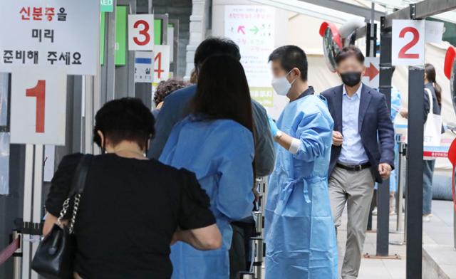 22일 오전 서울 용산구보건소 코로나19 선별진료소를 찾은 시민들이 검사를 받기 위해 줄을 서고 있다. 뉴스1