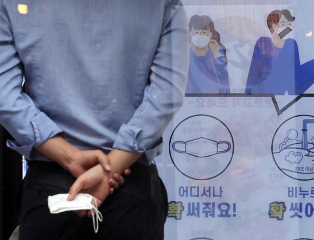 22일 서울 시내에서 한 시민이 마스크를 손에 들고 있다. 연합뉴스