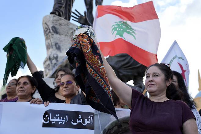 “여성에게 히잡을 강요하지 말라” 레바논 베이루트에서 21일(현지시간) 쿠르드 여성들이 20대 이란 여성인 마흐사 아미니의 죽음에 항의하는 시위를 벌이면서 히잡을 벗어던지고 있다. 베이루트 | AP연합뉴스