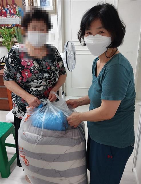 서울 도봉구의 한 세탁업체 대표(오른쪽)가 취약계층 어르신 가정을 방문해 세탁물을 전달하고 있다. 도봉구 제공