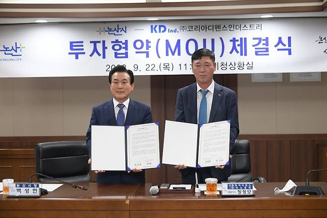 백성현 논산시장(왼쪽)이 정정모 KDI 대표이사와 투자 업무협약을 체결하고 협약서를 들어보이고 있다. (논산시 제공)