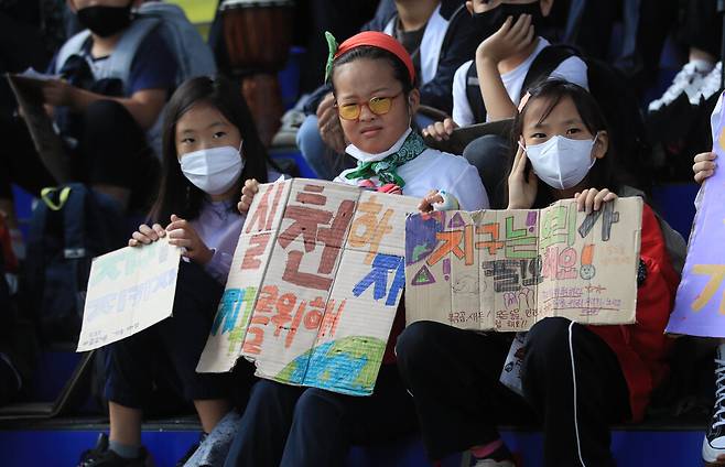 청소년기후행동 회원들이 23일 낮 서울 용산구 용산역광장에서 손팻말을 들고 있다. 박종식 기자