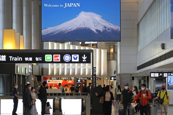 이달 7일 일본 정부가 ‘가이드 없는 패키지여행’을 허용한 뒤로 일본을 찾는 한국인이 급증하고 있다. 후지산 사진을 내걸고 외국인을 맞고 있는 도쿄 나리타 공항. [AP=연합뉴스]