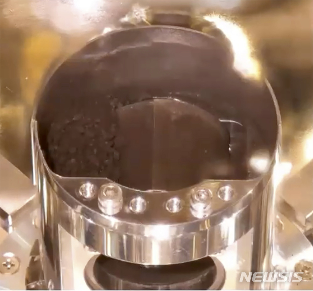 [도쿄=AP/뉴시스]지난 2020년 12월15일(현지시간) 일본 우주항공연구개발기구(JAXA)가 제공한 비디오 영상에 소행성 탐사선 '하야부사2'의 캡슐 개봉 후 용기 안에 토양 샘플이 보인다. 2022.09.23.