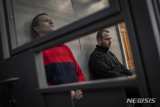 [코텔바=AP/뉴시스] 26일(현지시간) 우크라이나 북동부 코텔바에서 열린 2차 전범 재판에 러시아 군인 알렉산드르 블라디미로비치 보비킨(왼쪽)과 알렉산드르 알렉세이비치 이바노프가  출석해 있다. 우크라이나 검찰은 전쟁 범죄로 기소된 두 사람에게 각각 징역 12년을 구형했다. 2022.05.26.