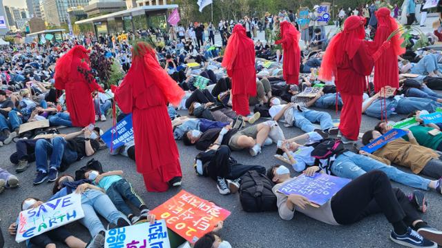 24일 서울 광화문 일대에서 기후정의행진 참가자들이 '죽은 듯이 눕는다'는 의미의 다이인(Die-in) 퍼포먼스를 하고있다. 이유진 기자