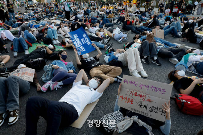 기후정의행동 관계자들과 시민들이 24일 서울시청 인근에서 “기후재난, 이대로 살 수 없다”라는 주제의 기후정의행진 도중 ‘죽은 듯이 눕는다’는 뜻의 다이-인(die-in) 시위를 하고 있다. 문재원 기자