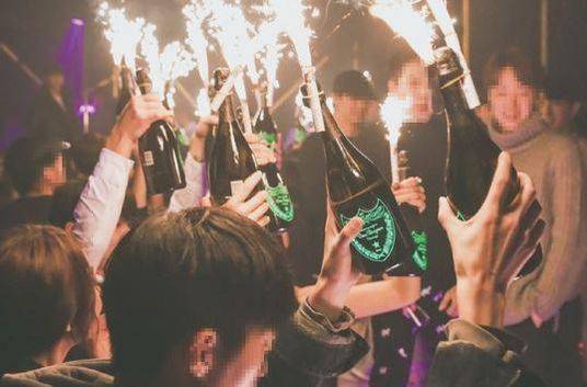 클럽에서 고급 샴페인을 들고 즐기고 있는 사람들.