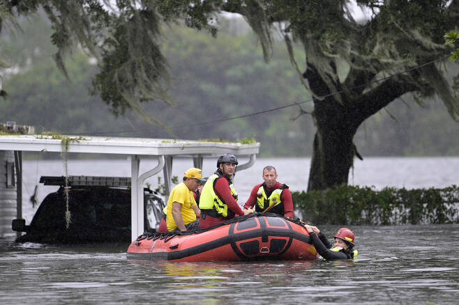 29일(현지시간) 허리케인 ‘이언’(Ian)이 휩쓸고 간 미국 플로리다주 올랜도에서 소방 구조대원들이 주민들을 구조하고 있다.AP 연합뉴스