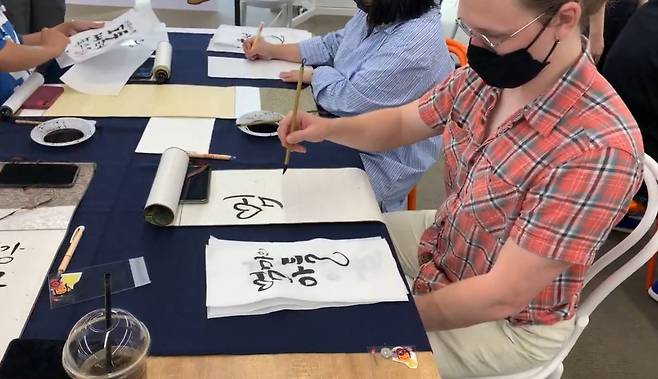 미국인 관광객이 ‘한국 서예 교실’(Korean Calligraphy Class)에 참여해 서예를 배우고 있다.