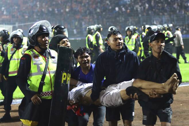 1일(현지 시각) 인도네시아 동부 자바주의 말랑의 칸주루한 축구장에서 시민들이 부상입은 관중을 이송하고 있다. /AP·연합뉴스