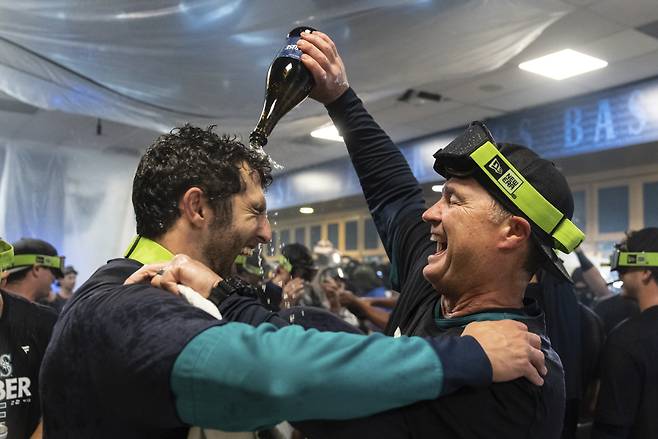 1일 끝내기 승리로 와일드카드 진출을 확정한 뒤 미국 프로야구 메이저리그(MLB) 시애틀의 스캇 서베이스 감독(오른쪽)이 선수단과 클럽하우스에서 축하파티를 즐기고 있다. 시애틀=AP 뉴시스