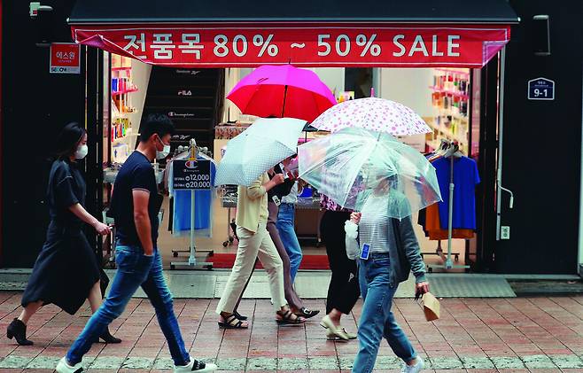 지난해 10월6일 비가 오는 서울 중구 명동 거리에서 철이 지난 여름옷 등을 할인 판매하는 상점 앞으로 시민들이 오가고 있다. 2∼4일 전국에 가을치고는 다소 많은 비가 내릴 전망이다. 강창광 선임기자 chang@hani.co.kr