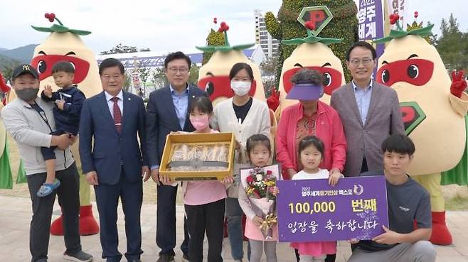 2022영주세계풍기인삼엑스포 행사장을 10만 번째 찾은 김서영 어린이가 기념품을 받은 후 기념사진을 찍고 있다. (영주시 제공) 2022.10.03