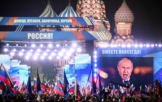 블라디미르 푸틴 러시아 대통령이 지난 9월 30일 모스크바 붉은광장에서 열린 우크라이나 점령지 4개 지역 합병 기념행사에서 연설하는 모습이 설치된 스크린에 비치고 있다. AFP=연합뉴스