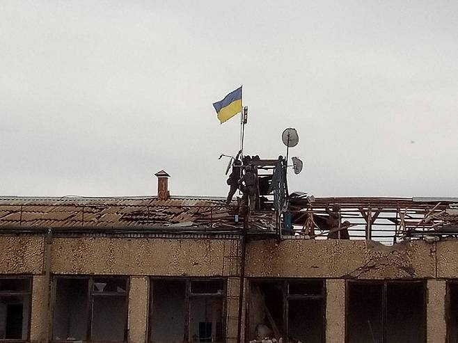 3일(현지시간) 우크라이나 남부 헤르손주(州) 미하일리우카에서 우크라이나군 병사들이 점령 중이던 러시아군을 몰아내고 건물 위에 우크라이나 국기를 게양하고 있다. [우크린폼 홈페이지 캡처]