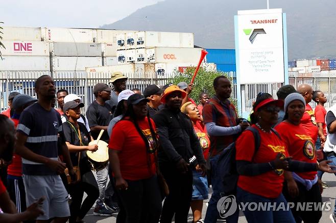 남아공 트란스넷 파업 (케이프타운 로이터=연합뉴스) 11일(현지시간) 남아프리카공화국 케이프타운에서 국영물류기업 트란스넷 노동자들이 전국적 파업을 하며 선박 컨테이너 앞을 지나고 있다. 2022.10.12 photo@yna.co.kr