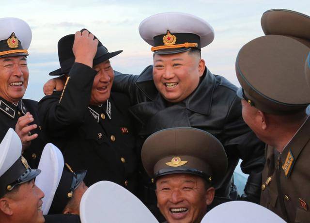 김정은 북한 국무위원장이 노동당 창건일인 10일 함경남도 함주군 연포지구의 연포온실농장 준공식에 참석해 김명식 해군사령관과 모자를 바꿔 쓰고 사진을 찍고 있다. 평양=조선중앙통신 연합뉴스