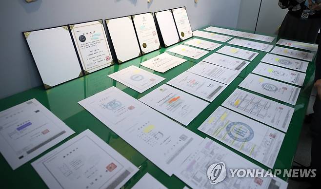취업·유학·승진 노리고 문서 위조 (대전=연합뉴스) 이주형 기자 = 25일 오전 대전경찰청 사이버범죄수사대 사무실에 경찰이 압수한 위조문서들이 놓여 있다. 경찰은 이날 학위 등 각종 위조문서 제작을 알선한 업자 5명과 이를 이용해 부정 취업과 진학을 시도한 구직자들 90명을 무더기로 검거했다고 밝혔다. 2022.10.25 coolee@yna.co.kr