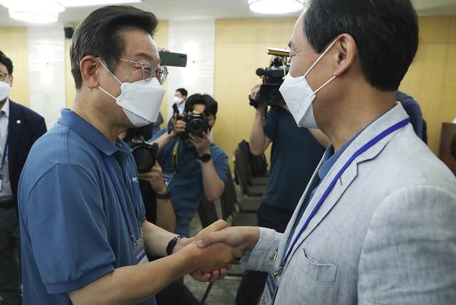 더불어민주당 우상호(오른쪽) 비상대책위원장과 이재명 의원이 지난 6월 24일 충남 예산군 덕산 리솜리조트에서 열린 국회의원 워크숍을 마친 후 인사를 나누고 있다. 뉴시스