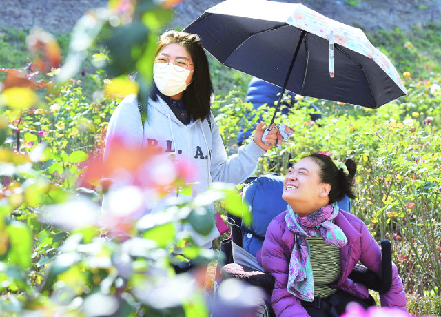 이윤정(오른쪽) 작가가 지난달 31일 서울 중랑구 중랑장미공원에서 이지현 장애인활동지원사와 산책하고 있다.