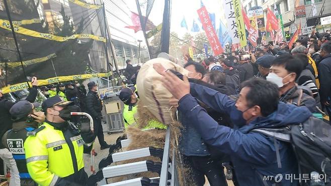 6일 오후 4시 30분쯤 서울 여의도 국민의힘 중앙당사 앞. 전국농민회총연맹 등 8개 농민 단체는 이날 낮 2시쯤 국회 앞에서 집회를 연 뒤 국회와 국민의힘 당사 방향으로 나눠 행진했다. 이들이 가지고 온 쌀나락을 국민의힘 당사를 향해 뿌리고 있다./영상=김도균 기자/사진=김도균 기자