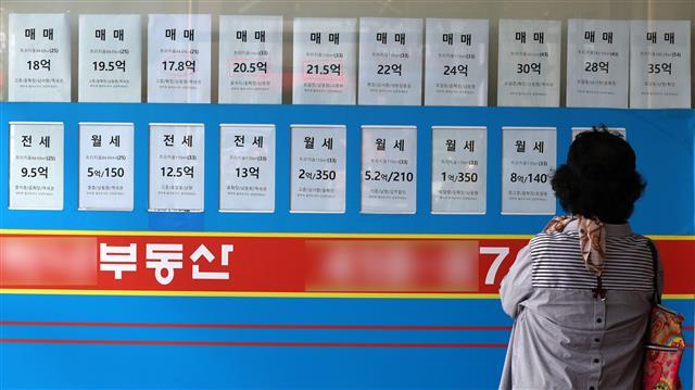 ‘잠실엘스’ 2년여 만에 20억 밑으로 - 21일 한 시민이 서울 송파구에 있는 부동산 중개사무소에 붙은 매물 가격표를 살펴보고 있다. 최근 부동산 가격 하락이 이어지고 있는 가운데 전날 국토교통부의 실거래가 시스템에 따르면 잠실동에 있는 대단지 ‘엘·리·트’(잠실엘스·리센츠·트리지움) 중 하나인 잠실엘스 전용 84㎡가 지난달 27일 19억 5000만원에 거래됐다. 해당 면적이 20억원 밑으로 거래된 것은 2년 전인 2020년 6월 이후 처음이다. 뉴스1