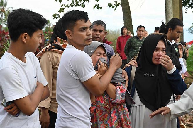 인도네시아 서자바주 치안주르에서 발생한 지진으로 사망한 후세인(48)의 장례식이 22일(현지 시각) 진행된 가운데 가족들이 울고 있다./AFP 연합뉴스