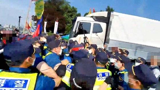 지난 6월 8일 하이트진로 경기 이천공장 앞에서 화물차 정상 운행 등을 방해하던 화물연대 조합원들 15명이 경찰에 체포되고 있다. 연합뉴스