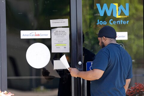 미국 미시시피 주 노스 잭슨에서 한 남성이 'WIN 잡 센터'의 유리문 뒤 경비원으로부터 실업수당 신청서를 건네받고 있다. /연합뉴스