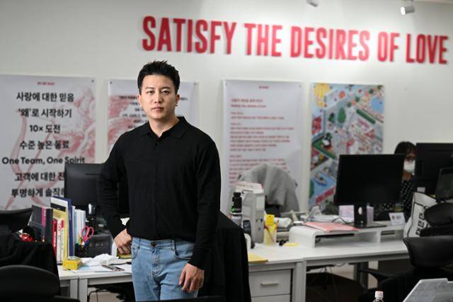 안재원 큐피스트 대표가 서울 테헤란로 큐피스트 사무실에서 국내 1위 만남 앱 '글램'에 대해 설명하고 있다. 그의 등 뒤로 보이는 '사랑의 열망을 충족하라'는 문구는 회사의 지향점이기도 하다. 최주연 기자
