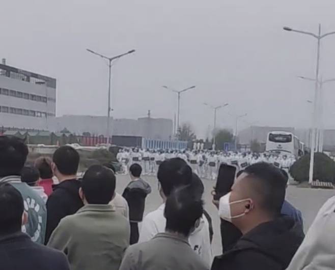 경찰과 대치 애플 아이폰을 생산하는 대만 기업 폭스콘의 중국 정저우 공장에서 23일 밀린 임금 지급과 작업환경 개선을 요구하는 노동자들이 방패를 든 경찰과 대치하고 있다. 트위터 캡처