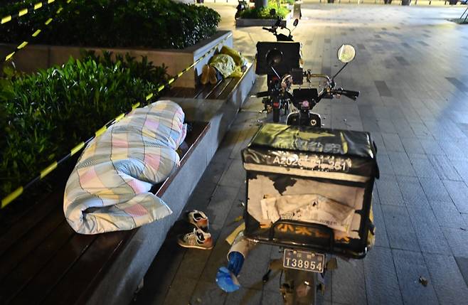 중국 선전시에서 지난 3월 코로나 봉쇄로 갈 곳 없는 외지 출신 배달원이 벤치에서 노숙하고 있다./웨이보