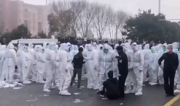 세계 최대 아이폰 생산 거점인 중국 정저우 폭스콘 공장에서 23일 흰 방호복을 입은 보안요원들이 시위를 벌이는 노동자들과 충돌하고 있다. 유튜브 영상 캡처
