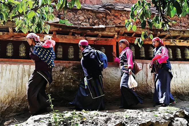 로기어곰파에 참석한 주변 마을 여인들이 전통복장으로 곱게 치장하고 기도를 하며 마니차를 돌리고 있다.