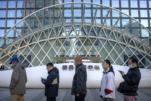 중국 인민은행은 25일 코로나19 충격에 따른 경기 둔화 속 올해 들어 두 번째로 지급준비율을 인하했다. 지난 15일 베이징 시내에 있는 한 코로나19 선별소에서 사람들이 줄을 서서 차례를 기다리고 있다. (사진=AP)