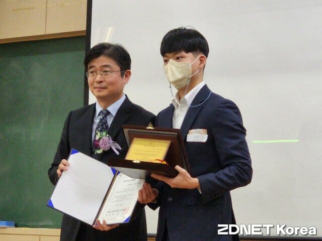 송찬우 학생(오른쪽)이 임규건 학회장에게서 최우수 논문상을 받고 있다.