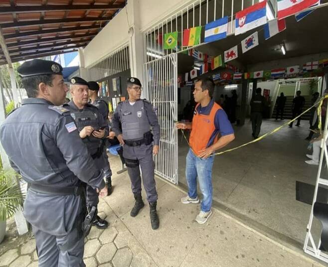 25일(현지시간) 브라질 이스피리투산투주 아라크루스에서 벌어진 총기 사건을 조사하기 위해 학교 입구에 서 있는 브라질 경찰들 모습. [사진 = 연합뉴스]