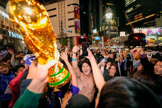 24일 새벽 일본 도쿄의 시부야 거리에서 일본 축구팬들이 2022 카타르 월드컵 일본 축구 대표팀이 독일을 상대로 승리한 것을 축하하고 있다. 일본이 월드컵에서 독일을 이긴 것은 이번이 처음이다. 도쿄=AP 뉴시스