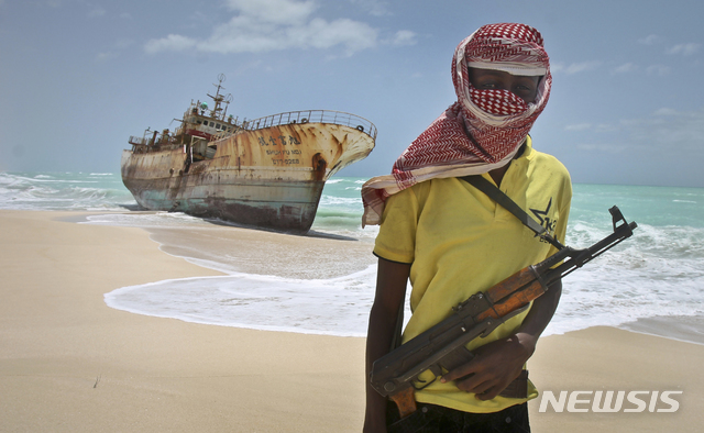 【호비요=AP/뉴시스】 2012년 대만의 어선을 납치해 석방금을 받아낸 소말리아 해적 한 명이 소말리아 호비요 부근에서 배 옆에 서 있다. 사진은 기사와 관련 없음. 2017.03.15
