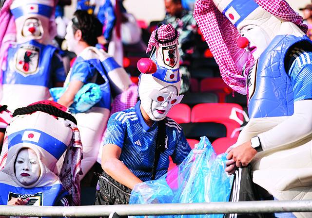 일본 응원단이 27일(현지시간) 카타르 알라이얀의 아흐마드 빈 알리 스타디움에서 열린 코스타리카와의 경기가 끝난 뒤 관중석에 버려진 쓰레기를 줍고 있다. AP연합뉴스