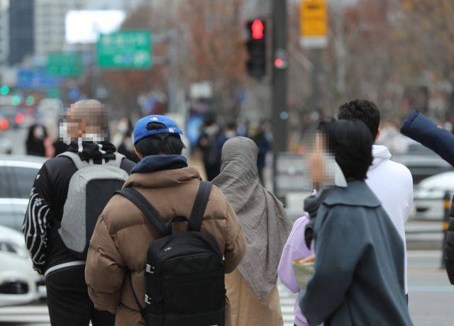 서울 광화문광장 인근에서 지난 28일 시민들이 두꺼운 옷을 입고 신호를 기다리고 있다. 연합뉴스